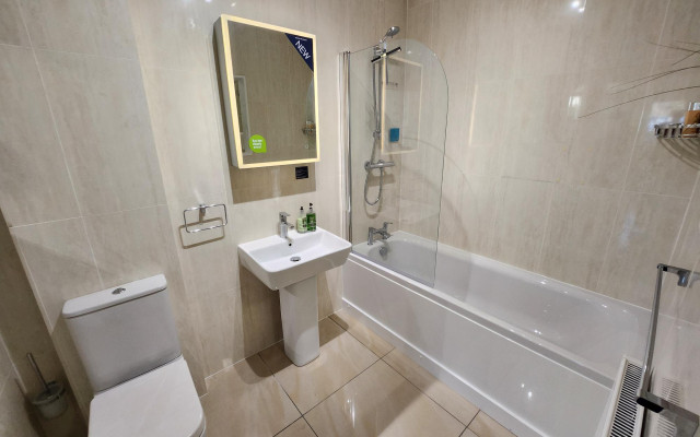 Modern white bathroom suite with beige panels and stylish fixtures.